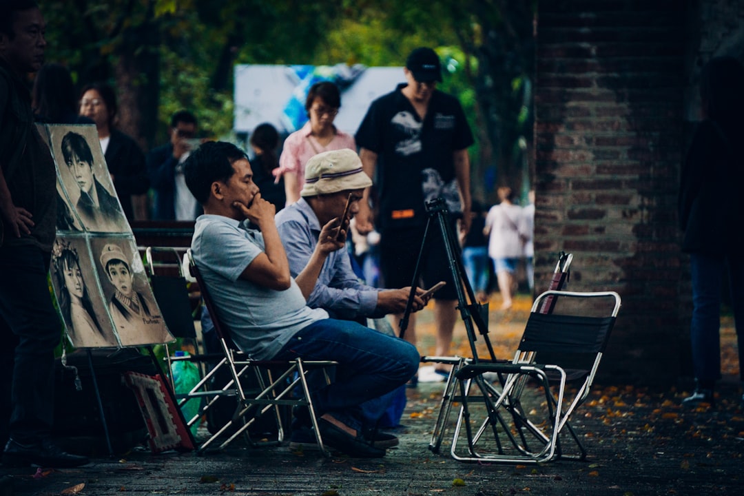 man in gray t-shirt sitting on black folding chair