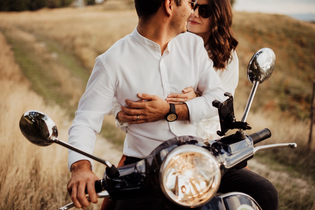 a man and woman on a motorcycle in a field