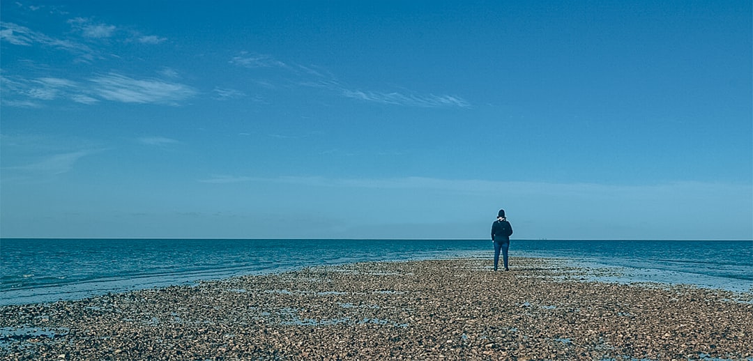 a person standing on a beach looking out at the ocean